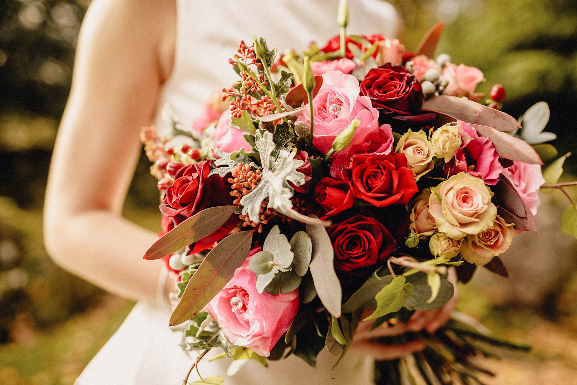 photograph of red floral boquet held by the bride