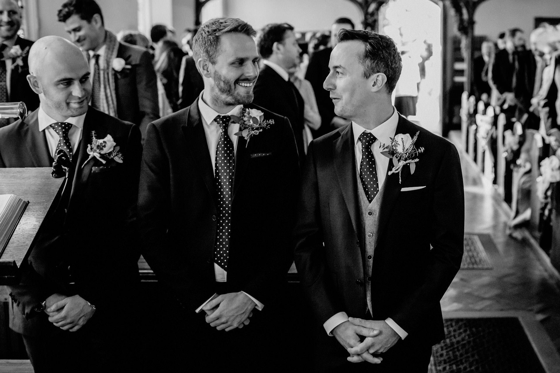 the groom and best man waiting at the front of the church